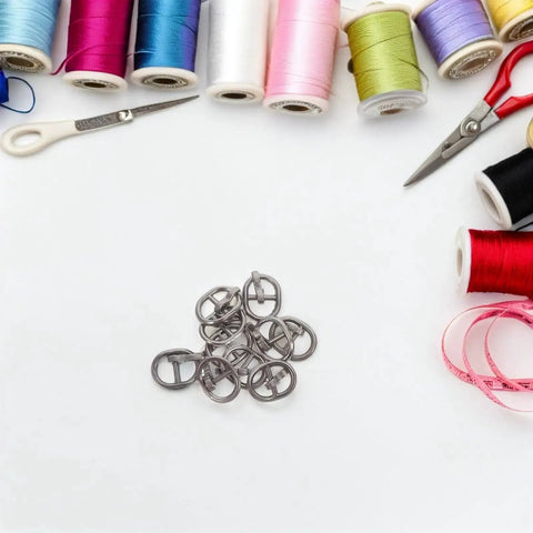 150 Pcs Miniature Alloy Buckles for Doll Clothes and DIY Projects, 5.5mm Single Prong Fasteners surrounded by sewing supplies