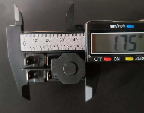 Close-up of a 4-pin electromagnetic pushbutton switch with caliper measurement, part of the Electromagnetic Pushbutton Switch Set, 4 Pin, 1/2 HP, Double Pole, 16A At 120V, Compatible With 120V And 220V Systems, Heavy Duty Starter Buttons For Garden Tools And Power Machinery, 2 Pack.