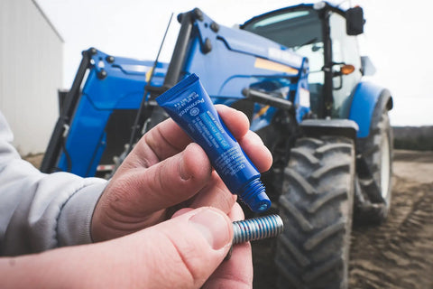 Blue Medium Strength Threadlocker for Fasteners 1 Quarter Inch To 3 Quarter Inch 6mL by Permatex held in hand with a bolt.