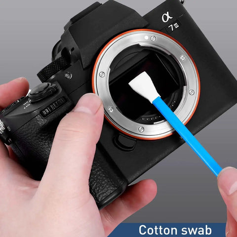 Using a cotton swab from the Camera Lens Cleaning Kit For Mirrorless And DSLR With Lens Pen Blower to clean a camera sensor.