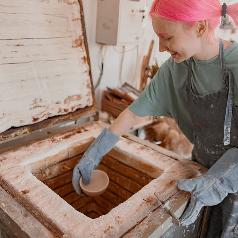 Ceramic fiber insulation blanket, white, 24x12x1 in, being handled by a worker beside a brick furnace/kiln.