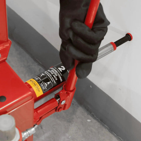 User operating 2 Ton Hydraulic Bottle Jack With Vertical And Horizontal Use Not For Trucks on concrete floor