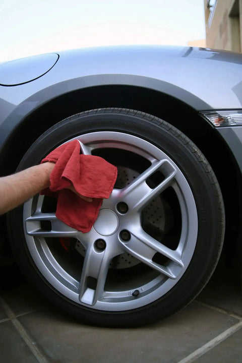Person using 150 Pack Cotton Shop Towels Rags 14x12 Inches Absorbent, Reusable Cleaning Rags for polishing a car wheel