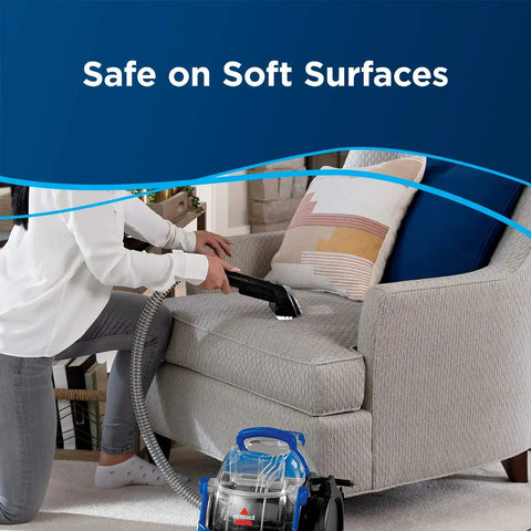 A person using the Pro Grade Portable Carpet And Upholstery Deep Cleaner For Stairs Rugs And Auto Interiors With 5.7A Motor 5ft Hose 3 In 1 Stair Tool Tough Stain Brush And Hydro Rinse Self Clean System BISSELL on a couch.