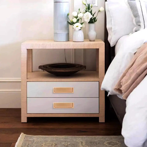 Nightstand with two drawers and gold handles in a bedroom setting