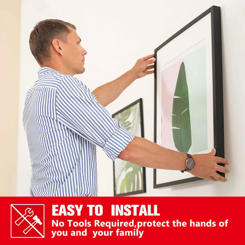 Double sided mounting tape used to hang a framed artwork on a white wall