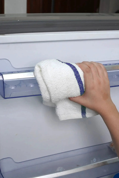 Hand using Bar Mop Towels Value Pack Of 60 16x19 Inches Absorbent And Durable Cleaning Rags for cleaning appliance surface