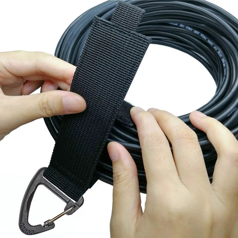 Hands using Eight Piece Heavy Duty Cable Organizer Set For Garage And Workshop Storage With Durable Straps Holds Cables Hoses And Ropes