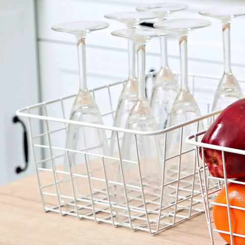Set Of 4 White Wire Storage Baskets For Freezer, Pantry, And Bathroom Organization with glassware and fruits on a counter