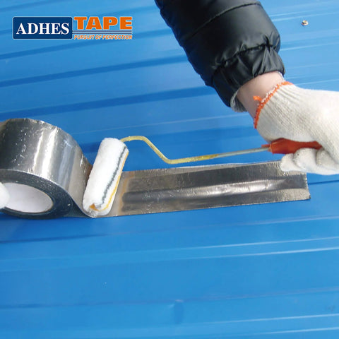 ADHES premium aluminum foil tape, 2 in x 210 ft, heat resistant to 100°C, applied to metal duct surface with roller.
