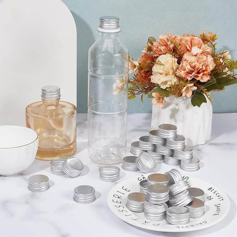36 Pack Silver Aluminum Seal Screw Caps for Round Steel Tins with Plastisol PE Liner, 30mm/1.2in x 13mm/0.5in Thick, Fits 27mm/1.1in Inner Diameter, Airtight Leakproof Kitchen Home displayed on a marble surface surrounded by bottles and flowers.