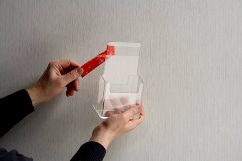 Hands using VHB 4910F Clear Double-Sided Acrylic Adhesive Tape for invisible bonding on transparent material container.
