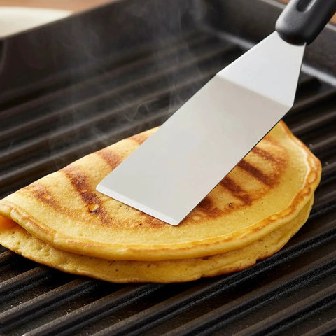 10 Piece Mini Stainless Steel Spatula Set With Five Solid And Five Slotted Spatulas for Kitchen Cooking, flipping a pancake on a grill pan.
