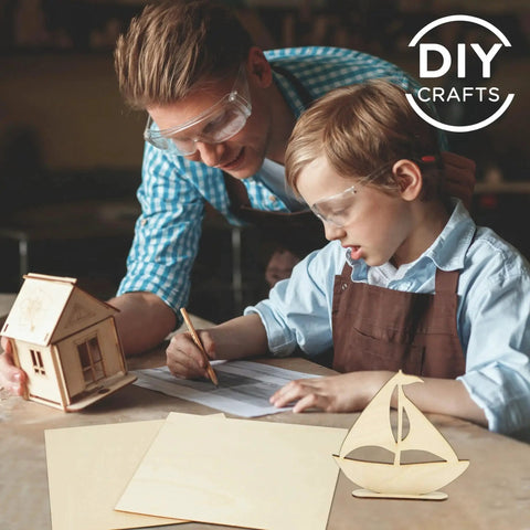 Father and son using Craft Basswood Sheets For DIY Projects 12 Pack 11.8 By 11.8 Inches Thick One Sixteenth Inch Smooth Plywood Sheets Great For Laser Cutting Model Building Wood Burning And Staining LotFancy with sailboat and house model crafts.