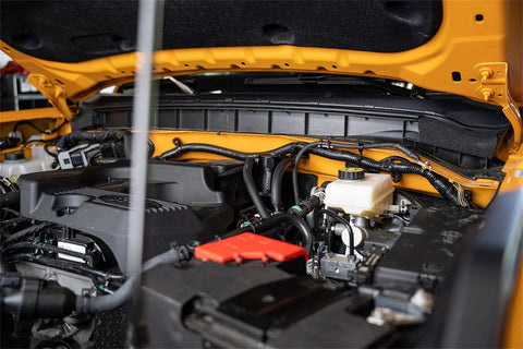 Ford Bronco 2.3L engine with installed catch can, showing aluminum 6061 construction and OEM style quick disconnect fittings.