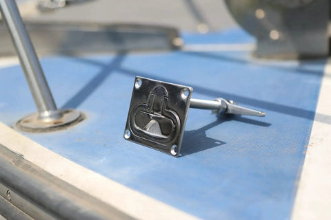 Close-up of a MIZUGIWA stainless steel large flush hatch latch with back plate on blue deck.