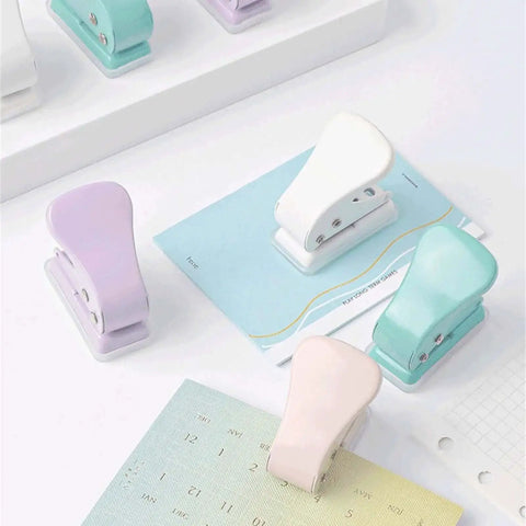Assorted colored quarter-inch single hole punchers on a desk, featuring 6mm round holes and 10 sheets capacity for DIY projects