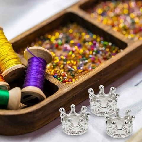 50 Piece King Crown Charms 3D Mini Alloy Beads for DIY jewelry making with colorful threads and beads in background, silver tone