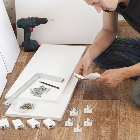 Person assembling furniture with 120 Pcs Drawer Bottom Support Brackets With Screws Plastic Drawer Wedges And Corner Brackets Repair Kit.