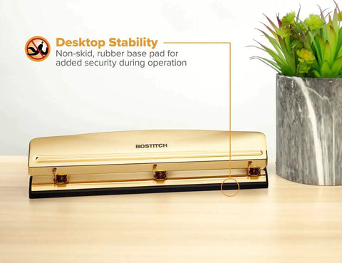 Gold 3 Hole Punch For 12 Sheets Durable Metal Office Punch With Stable Rubber Base on desk next to plants