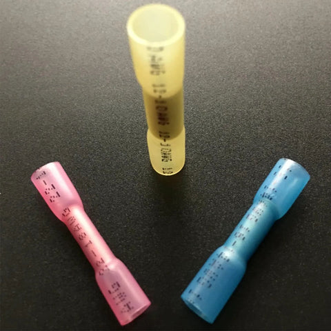 Three heat-shrink butt connectors in pink, yellow and blue for waterproof electrical wire crimp splices.