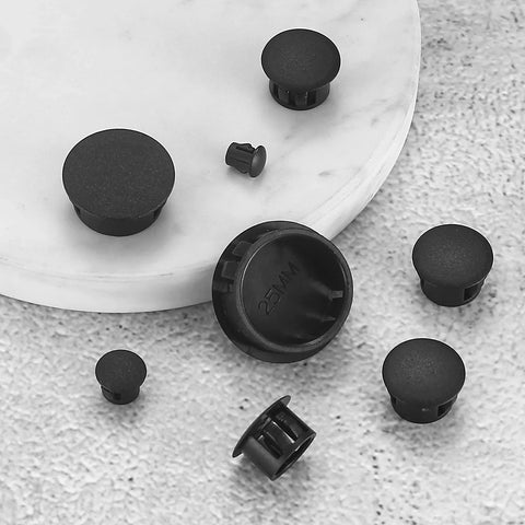 Round Black Plastic Hole Plugs Kit, 180 Pcs Self-Locking Panel Knockout Plugs for Kitchen Cabinets displayed on marble surface.