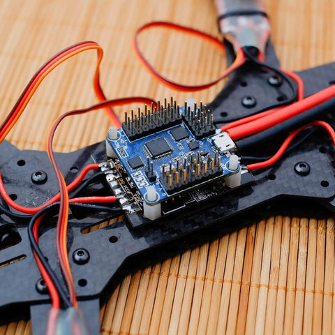 RC flight controller mounted on drone frame with wiring, showing anti vibration rubber balls set for F4 and F7 M3x8mm mounting.