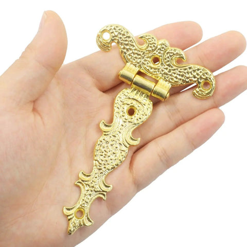 Hand holding Antique Gold Medieval Door Hinge from 4 Pcs 4.45 By 2.72 Inches T Strap Hinge Retro Carved Hardware for Barn Door Gate.