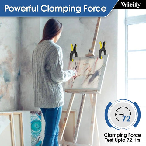 6-Inch heavy duty plastic spring clamps, pack of 4, black with yellow grips securing a canvas on an easel