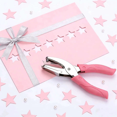 Pink star hole puncher next to decorated cardstock; Two Pack Handheld Heart And Star Shape Hole Punches With Ergonomic Soft Grip, 5mm Star And 5.5mm Heart Puncher For Paper Crafts, Scrapbooking, Tags, Tickets, DIY Projects, Pink And Green.