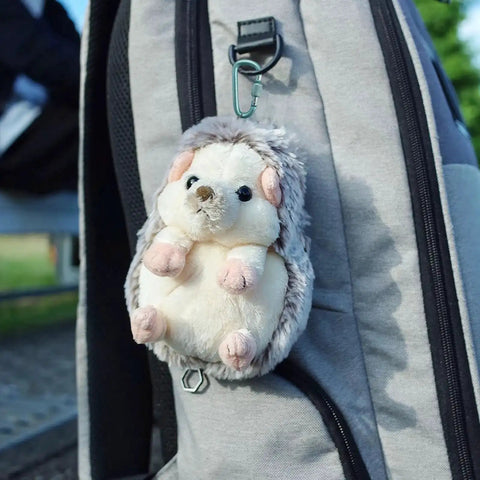 Stuffed hedgehog toy attached to a gray backpack using 8 Pack D Shape Carabiner Clips With Screw Gate, 2.2 Inch Aluminum Keychain Hooks