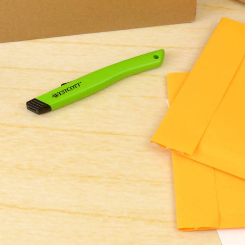 Green Ceramic Safety Box Cutter With Retractable Blade For Easy Large Box Opening on a table with folders