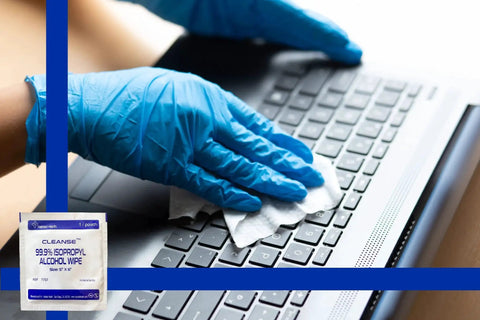 Gloved hand cleaning a laptop keyboard with 99.9 Percent Isopropyl Alcohol Wipes For Electronics And Screens 50 Count 6x5in pack shown