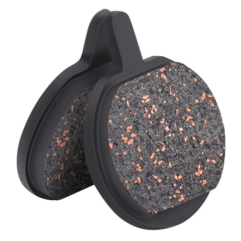 Pair of round bicycle disc brake pads with black backing and orange-speckled friction surface