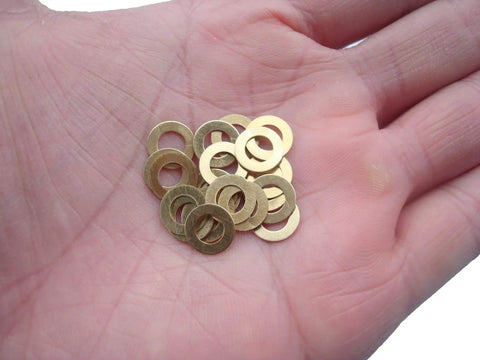 Hand holding EDC Knife Brass Washer Gasket Replacement Set For Bugout Axis Lock 535 Folding Knife 20 pack of brass washers