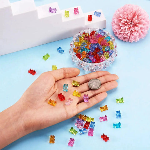 Hand holding multicolor 400Pcs Gummy Bear Acrylic Beads Transparent 12x8mm for jewelry making, with coin for size reference