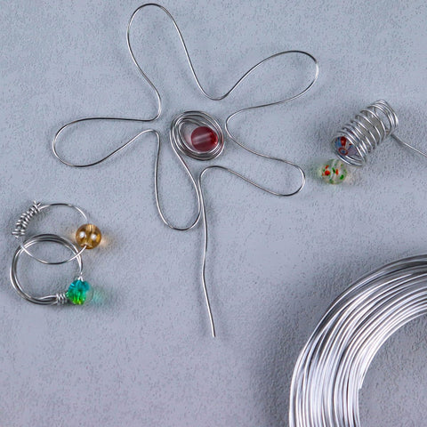 18 Gauge Aluminum Craft Wire 1mm 164ft Silvery Bendable Metal For Sculpting Doll Armature Flexible DIY Jewelry Making And Craft Projects, arranged with beads and crafted flower shape.