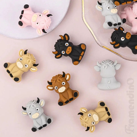 20 Pack Highland Cow Silicone Beads Set For DIY Jewelry And Crafts, colorful cow-shaped spacers on pink surface