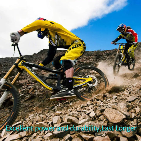 Side view of two mountain bikes on a rocky downhill trail; riders in yellow gear and helmets.
