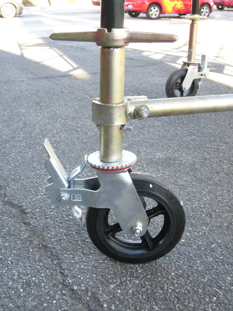 Side view of scaffolding with an installed Set Of Four Eight Inch Caster Wheels With Cast Iron Hubs And Locking Brakes CBM1290 Heavy Duty 1100 Pound Load Capacity One And Three Eighths Inch Stem Fits Two Hole Mounting For Two Inch And Two And A Half Inch Tubes Swivel 360 Degree.
