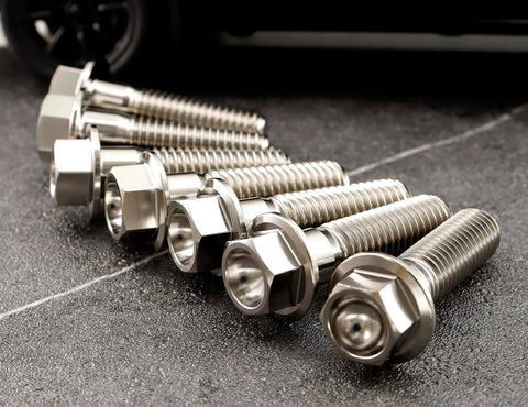 Titanium M6 Flanged Hex Bolts Set, 1.0mm Pitch, Assorted Lengths 5 To 80mm, Ti 6Al 4V Grade 5 Alloy, close-up view on ground