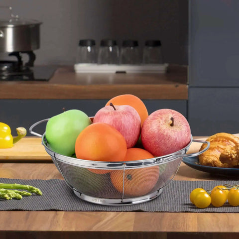 Three Pack 18/8 Stainless Steel Colander Sieves Set With Handy Handles and Resting Base holding fresh fruit on kitchen counter