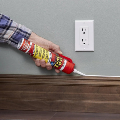 Person using Waterproof Hybrid Caulk Sealant Paintable Indoor Outdoor No Caulk Gun Needed along a wall seam near an outlet.
