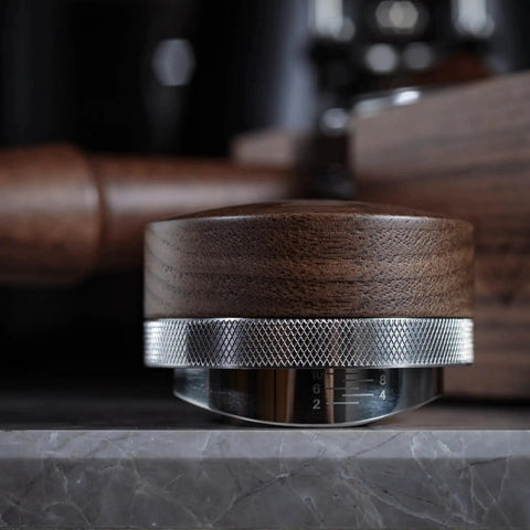 Side view of Walnut 58.35mm Espresso Distribution Tool, Adjustable Depth, Stainless Steel Leveler For 58mm Portafilters on a counter.