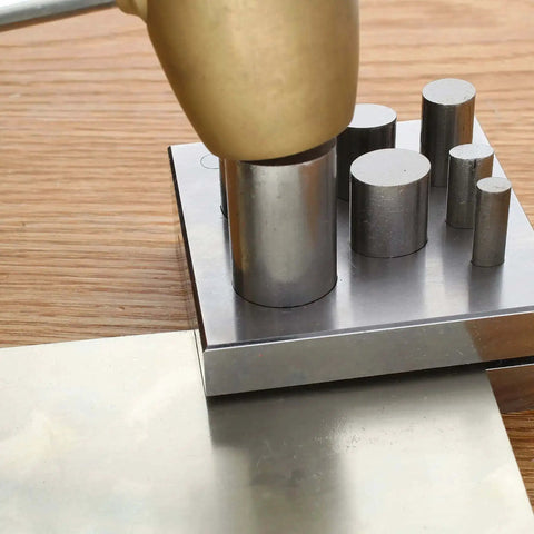 Oval Disc Cutter Set With Seven Punches And Die for Soft Metal Up To 14 Gauge, showing tool in use on wooden table