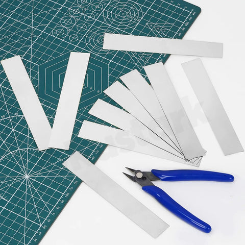 10 Piece Stainless Steel Shim Kit For Kitchen Trim Gap Filler And Sheet Metal Projects, 304 Stainless Steel Strips laid out on a cutting mat.