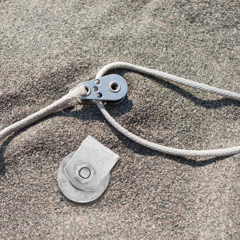 Heavy Duty Pulley Wheel Track Roller For Sliding Gates And Garage Doors Beefy Stainless Steel Design shown with rope on sand