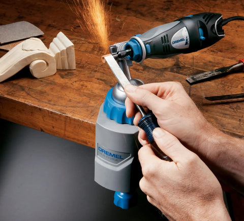 Person using 3 in 1 Multi Vise Attachment for Dremel Rotary Tool Stationary Vise as sparks fly during wood shaping in workshop
