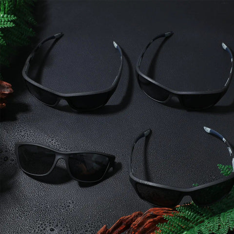 4 Pack Men Polarized Shades With UV Protection For Driving Sports And Outdoor Activities Lightweight TAC Lenses And Durable PC Frame All Day Comfort In Cool Black shown on a textured surface with a nature backdrop.