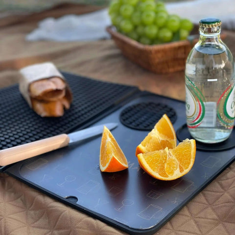 Multifunctional Folding Bar Mat for Home Bars and Travel Silicone Cocktail Prep Mat With Cutting Board Drip Tray And Countertop Protection shown with sliced oranges and a bottle